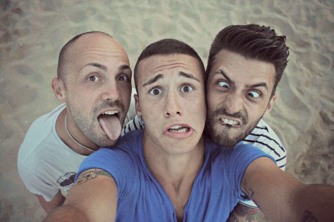 three men taking a goofy selfie
