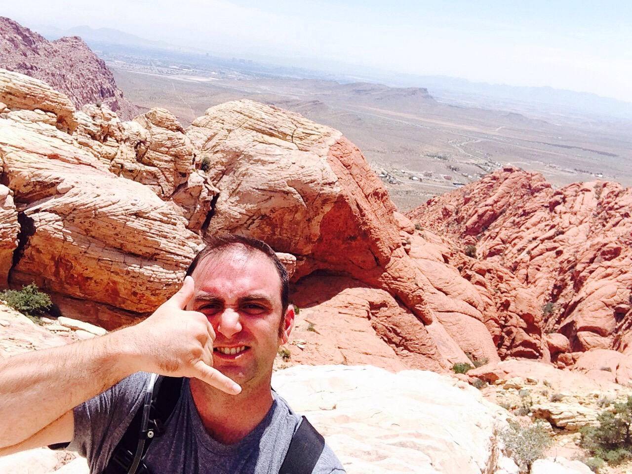 man with strained expression and strange hand gesture at red rock canyon in las vegas