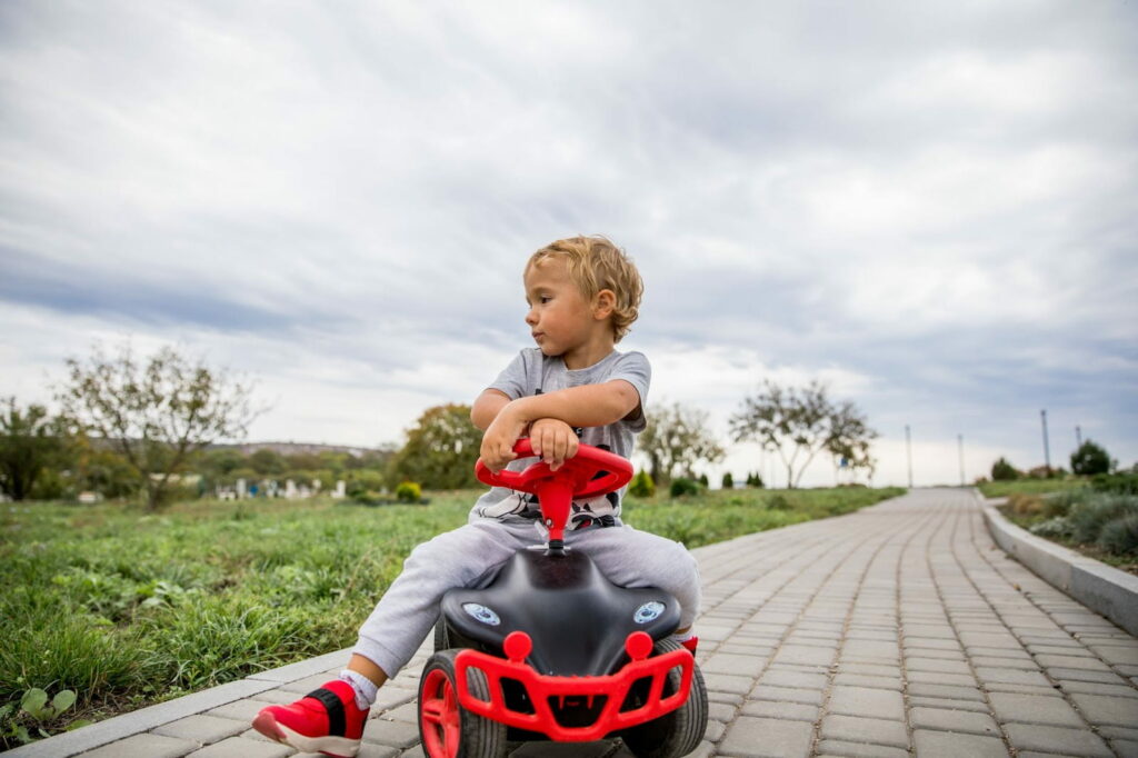 child on toy car