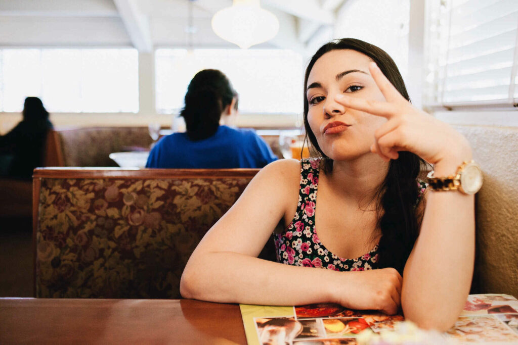 outgoing girl with peace sign at cafe