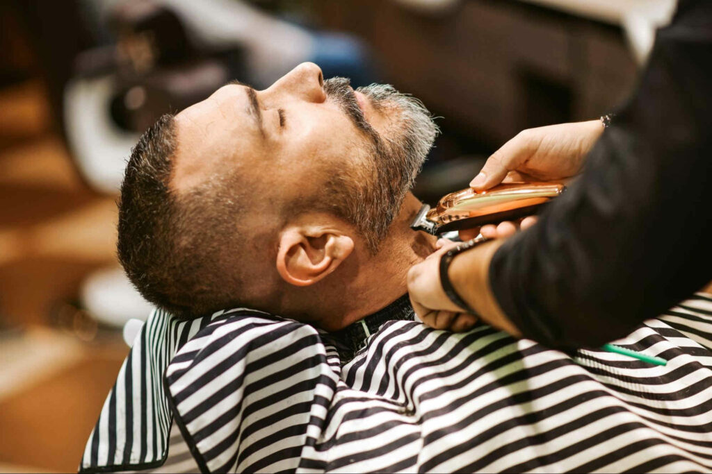 man getting his beard trimmed at a barber