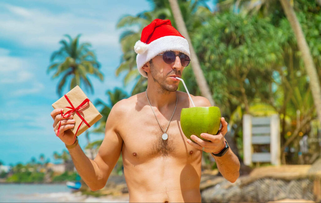 drinking coconut on beach man as santa