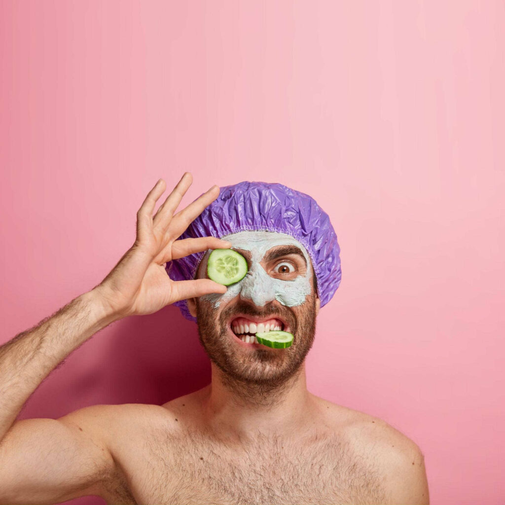 man with shower cap and cucumber mask funny face