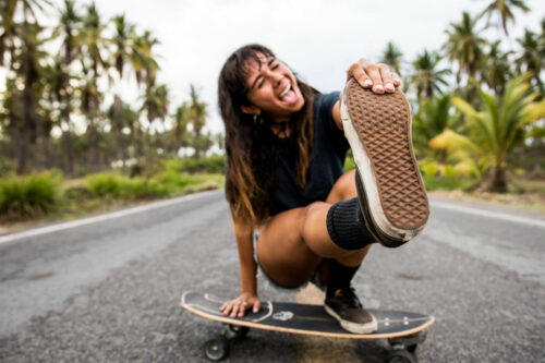 capture your vibe girl on skateboard with shoe to camera happy energy