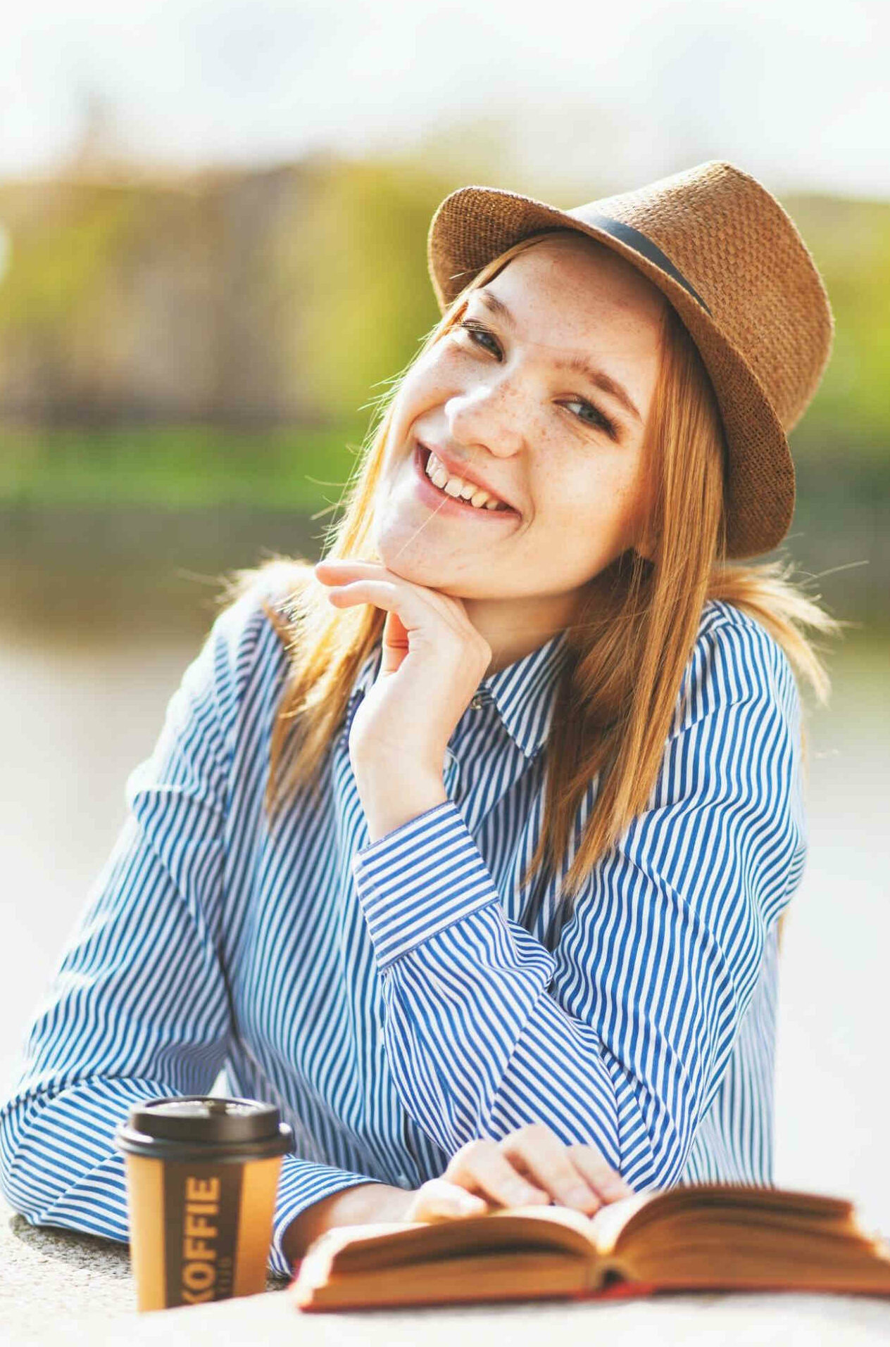 girl in brown hat tilting her head and smiling
