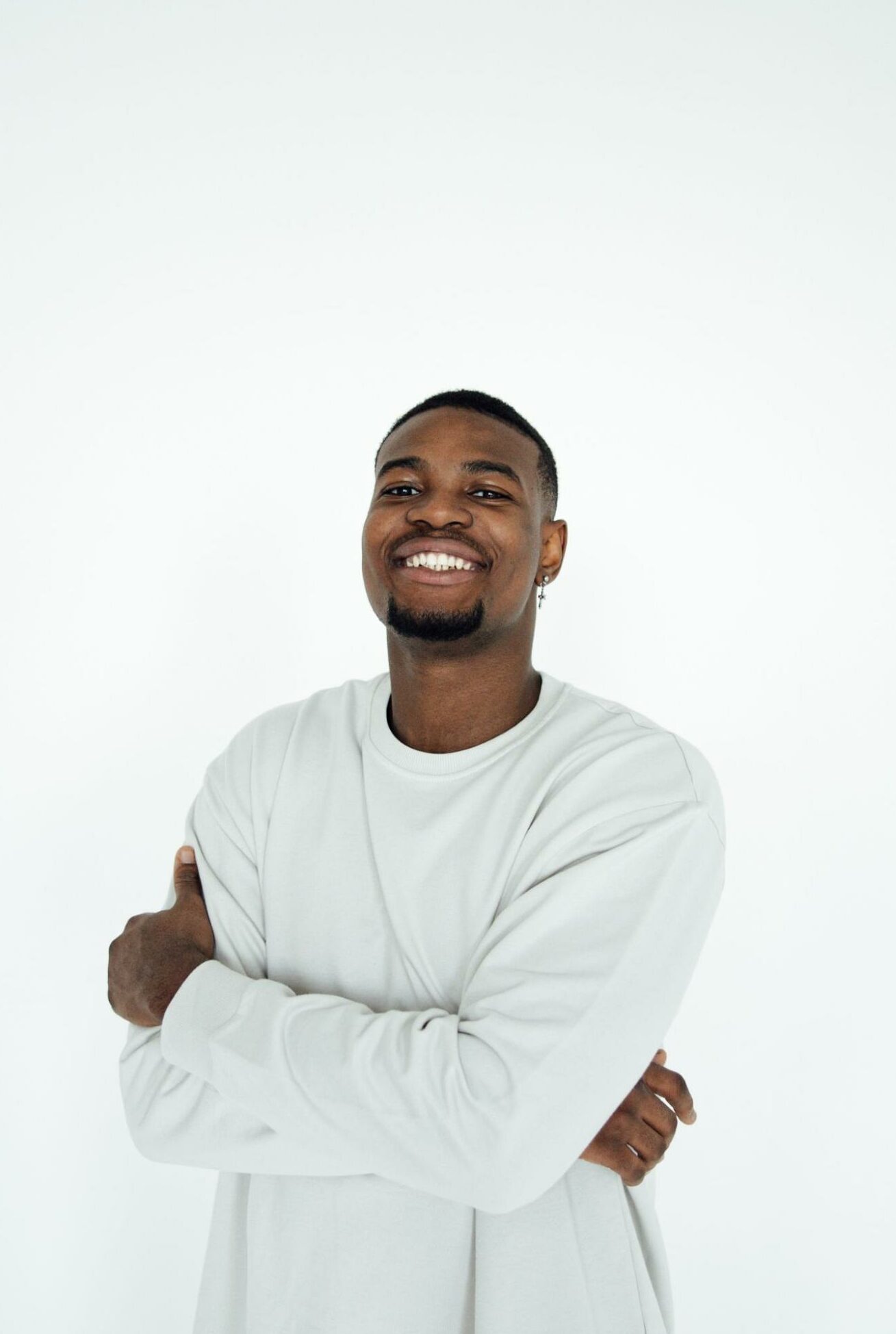 man smiling against white background in white shirt, clean portrait