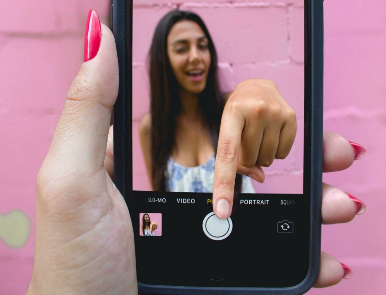 woman reaching through phone optical illusion edit