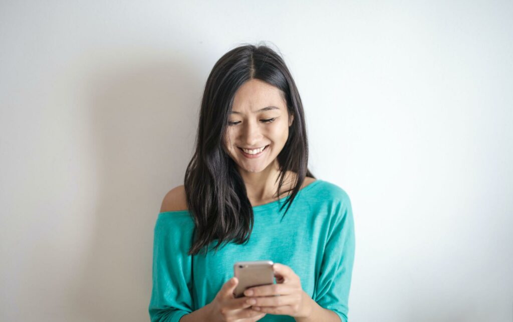 woman smiling at phone, online dating
