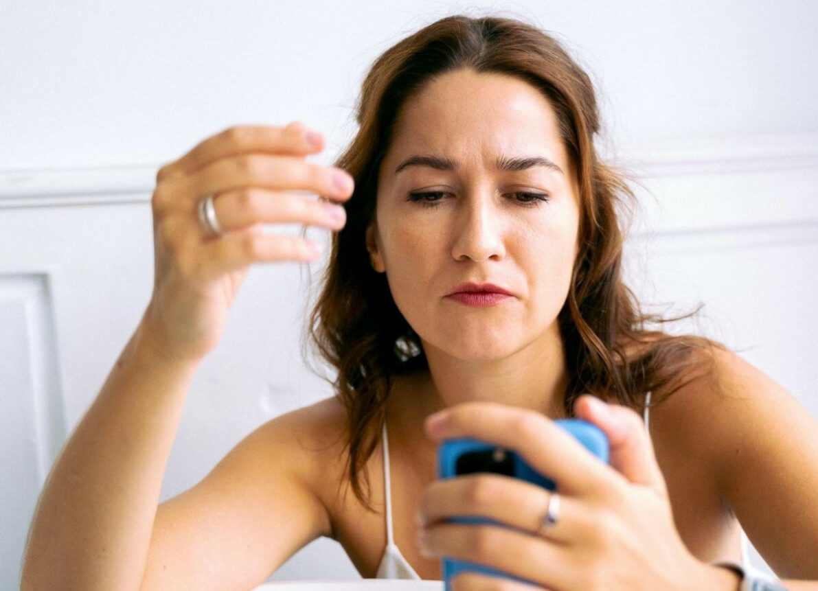 woman looking at her phone conused with dating app
