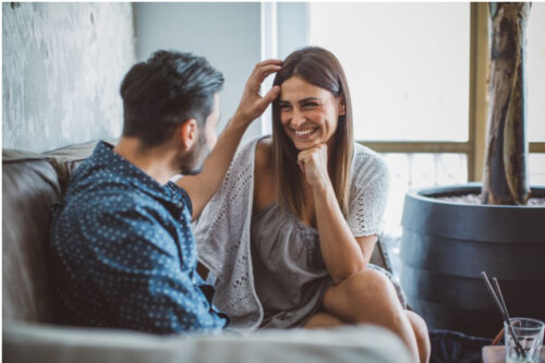 man and woman talking on the couch, smiling