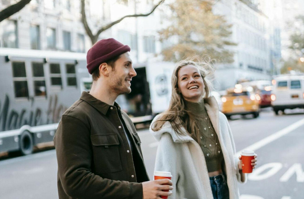 first date ideas, couple walking with coffee in hand