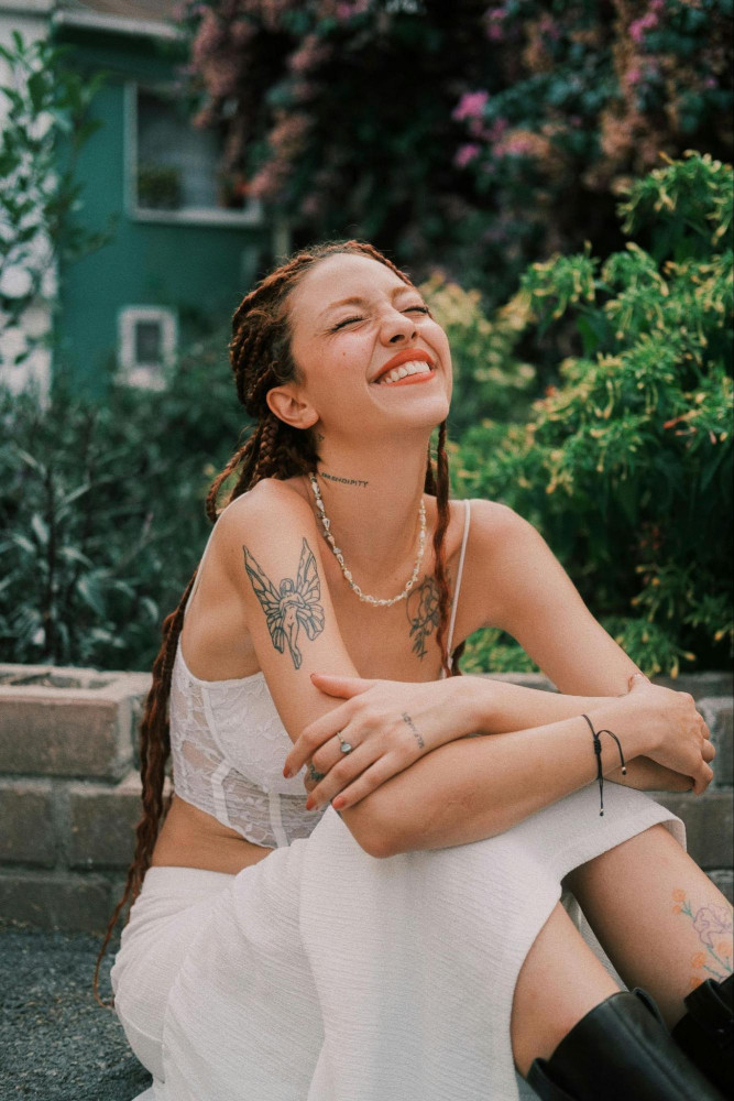 woman with tattoos laughing, eyes closed, dating photoshoot