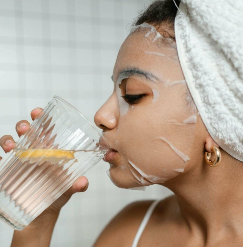 woman with face mask, drinking water to prepare for her dating photoshoot