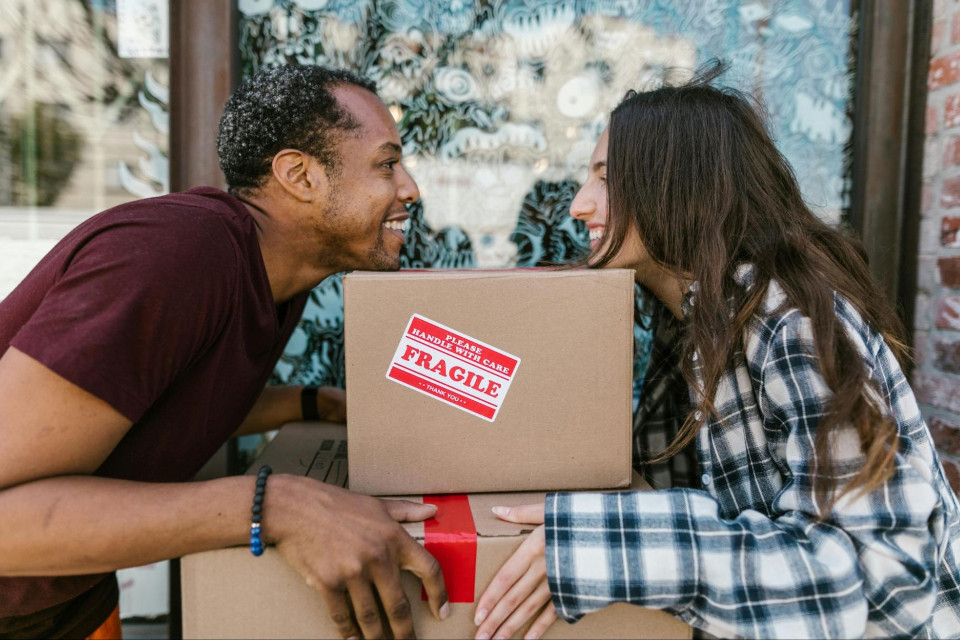 a couple smiling and putting their chins on a box