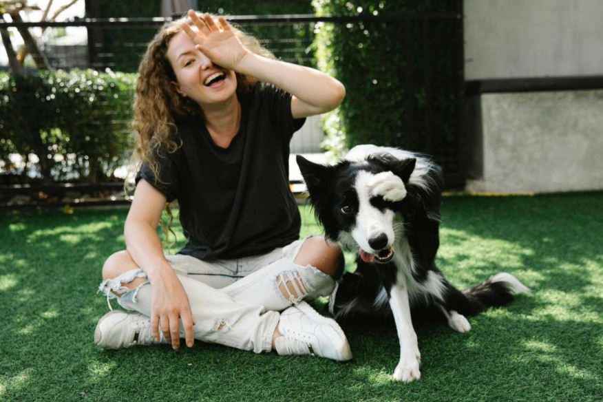 woman with her dog, sitting on grass