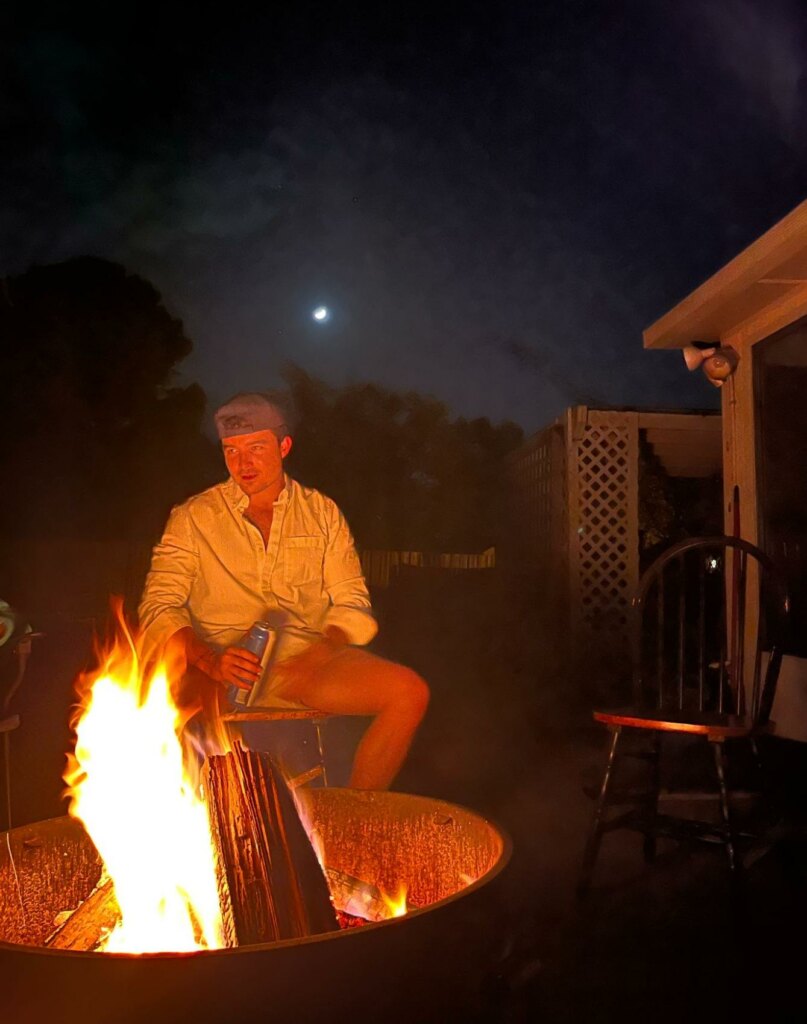 man sitting by a campfire