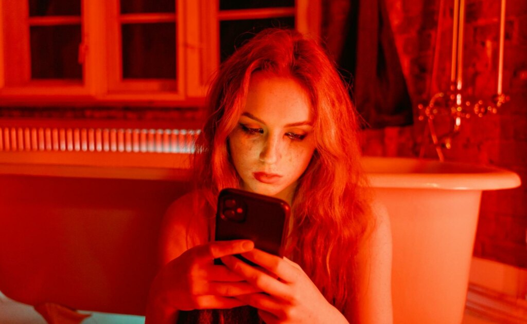 woman texting in red room