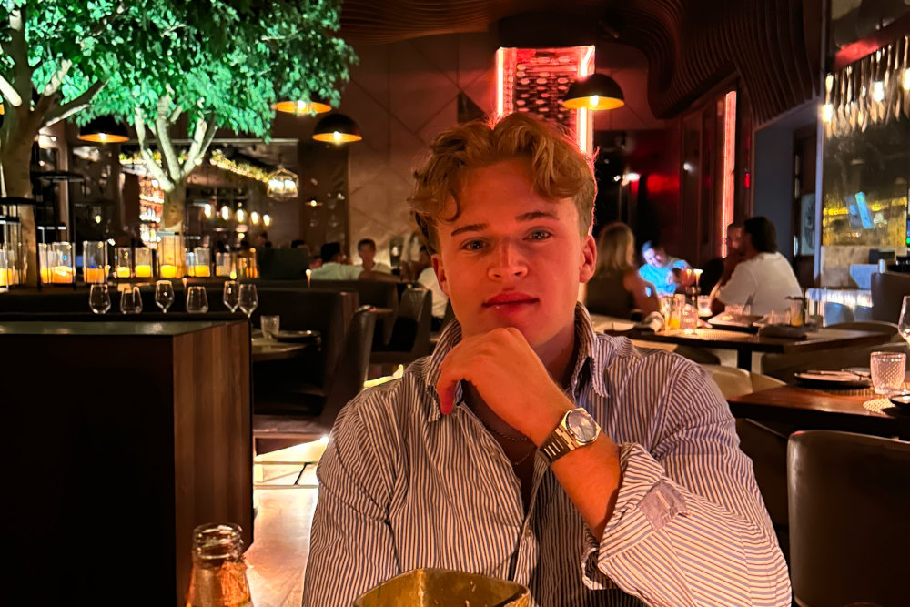 well-dressed man in a classy bar, showing off tastefully, good expression