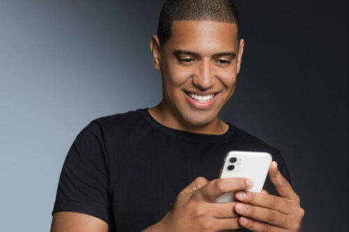 man smiling at his cell phone as he's scrolling tinder